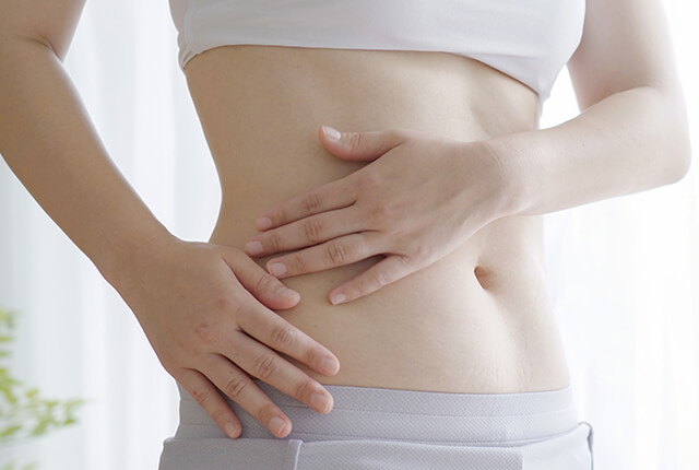 両手でウエストを触る女性
