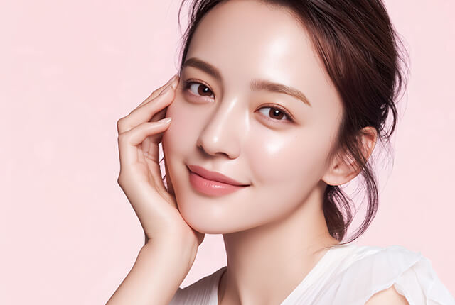 右手を頬に当てて微笑む女性